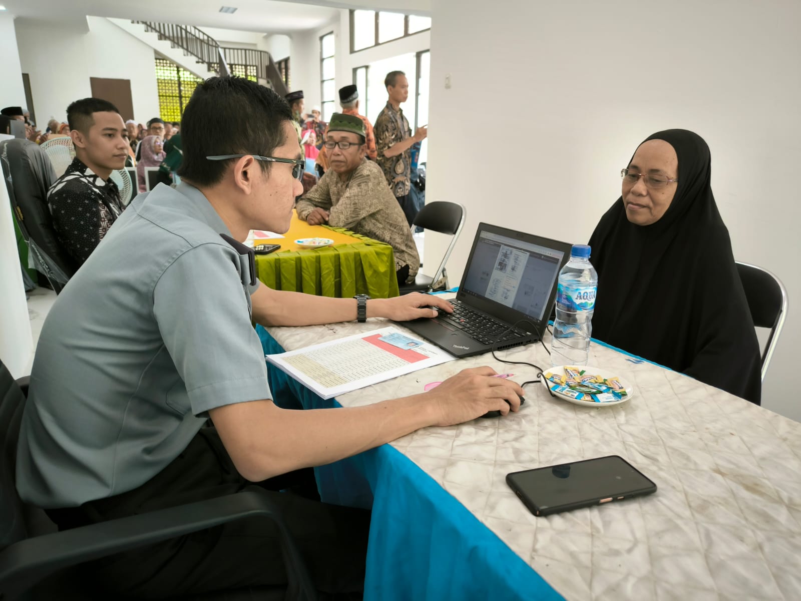 Foto : Istimewa/Radar Gresik PERKAMAN : Petugas Imigrasi (Kanim) kelas I TPI Tanjung Perak, Surabaya saat melakukan perekaman foto paspor jamaah haji di kantor Kemenag Gresik.