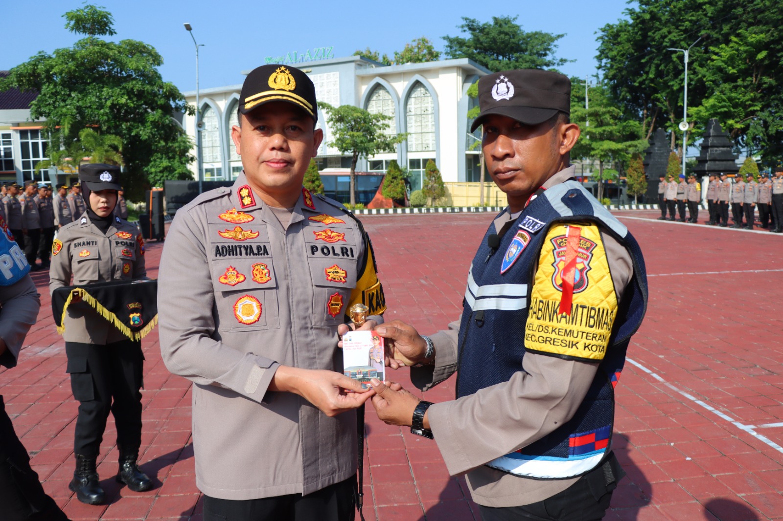 BERI BUKU SAKU: Kapolres Gresik AKBP Aditya Panji Anom memberikan buku saku panduan pengamanan pemilu 2024 dan netralitas Polri kepada anggota Polres Gresik di halaman Mapolres Gresik.