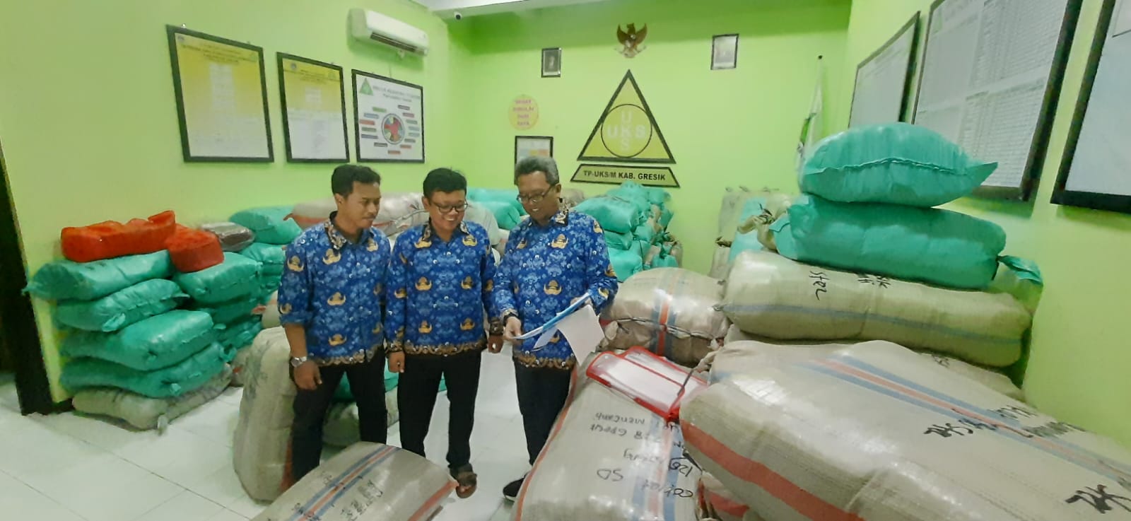 MEMANTAU: Sekretaris Dispendik Gresik Herawan Eka Kusuma saat melihat langsung proses distribusi seragam gratis SD, kemarin