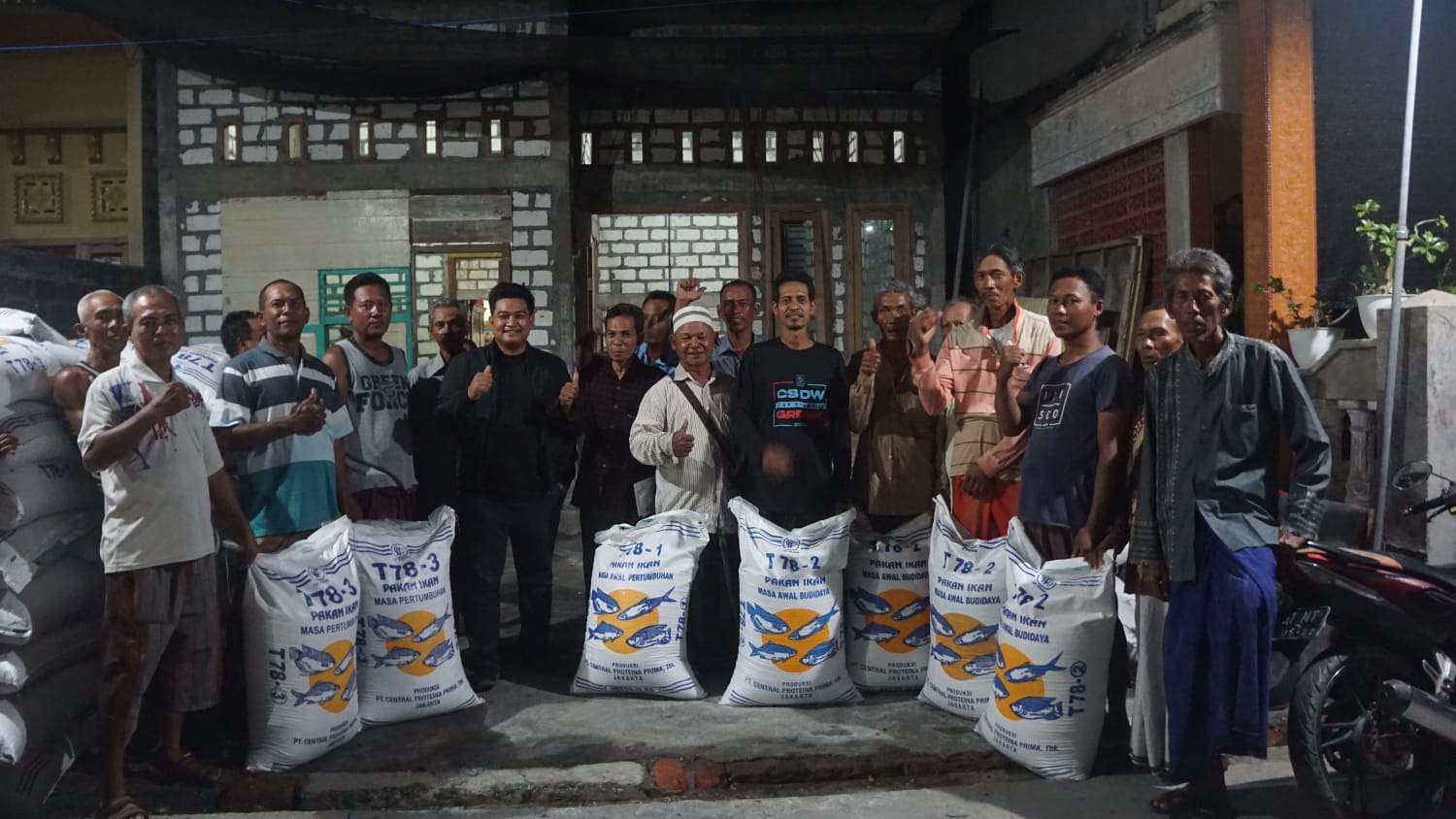 BAGI PAKAN IKAN: Syahrul Munir membagikan pakan ikan ke warga untuk meningkatkan hasil perikanan.
