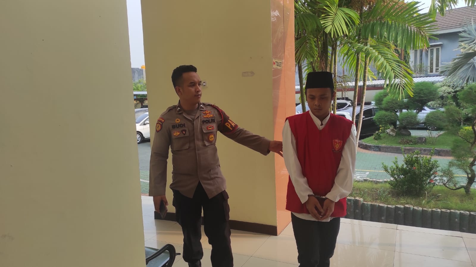 TERTUNDUK: Terdakwa M Anaf Tantowi hanya duduk dikawal petugas usai mengikuti sidang tuntutan di PN Gresik.