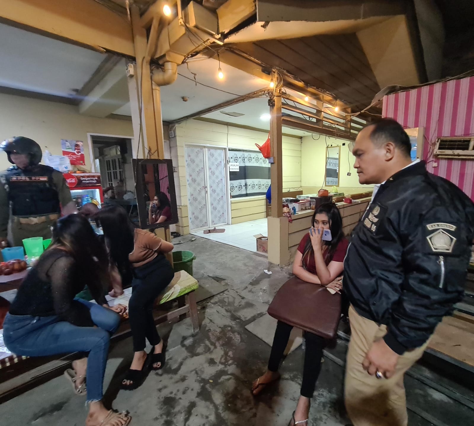 TERTANGKAP BASAH : Kepala Dinas Satpol PP Pemkab Gresik, AH Sinaga (kanan) bersama personil Tim Pudak menggerebek sebuah ruko di Jalan Veteran yang selama ini menjadi lokasi pesta miras.