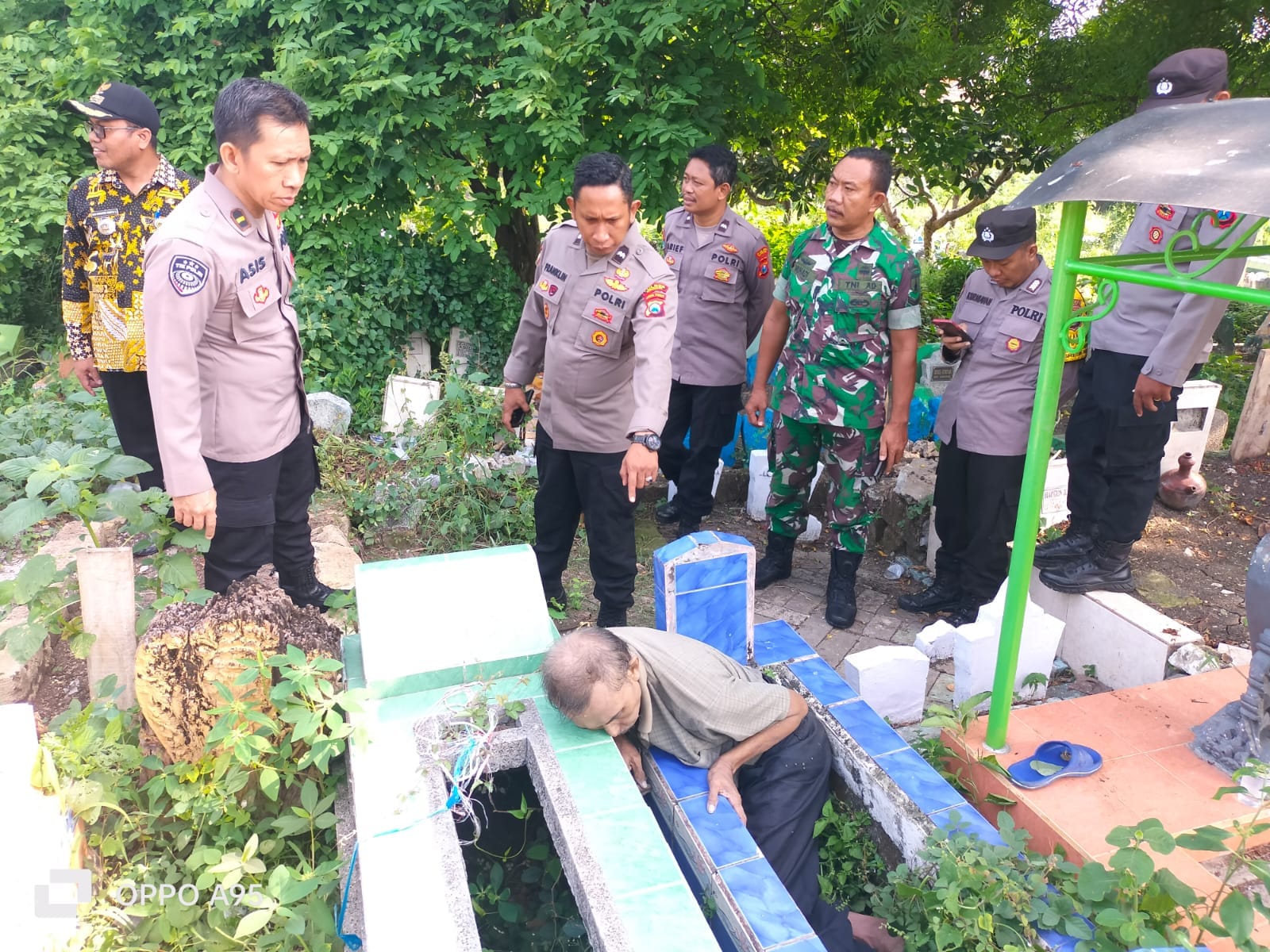 OLAH TKP : Anggota Polsek Kota Gersik, tim kesehatan dari Puskesmas Nelayan dan anggota koramil Kota saat melakukan evakuasi korban di TPU Islam Desa Tlogo Pojok, Kecamatan Gresik.