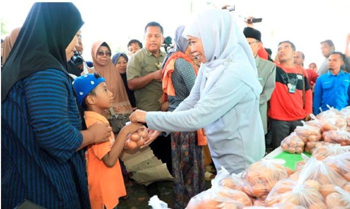 MENATAP SAYANG: Gubernur Khofifah menyerahkan bantuan bahan makanan berupa telur ayam untuk calon generasi emas, anak-anak, di Jawa Timur. (FOTO: ANDY SATRIA/RADAR SURABAYA)
