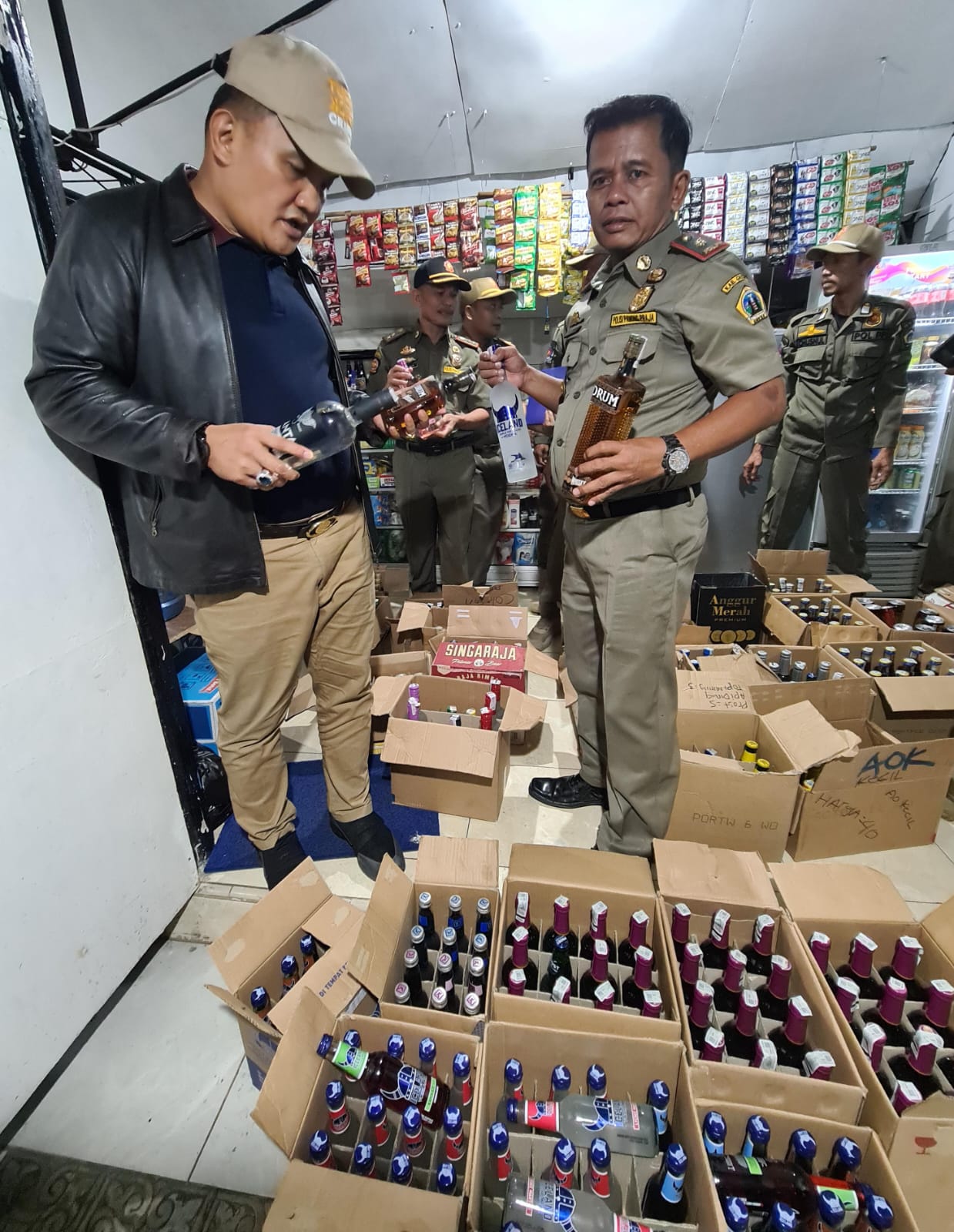 BERANI: Kepala Satpol PP Gresik Agustin H Sinaga langsung mengawal proses razia miras di Warkop dan Konter Handphone.
