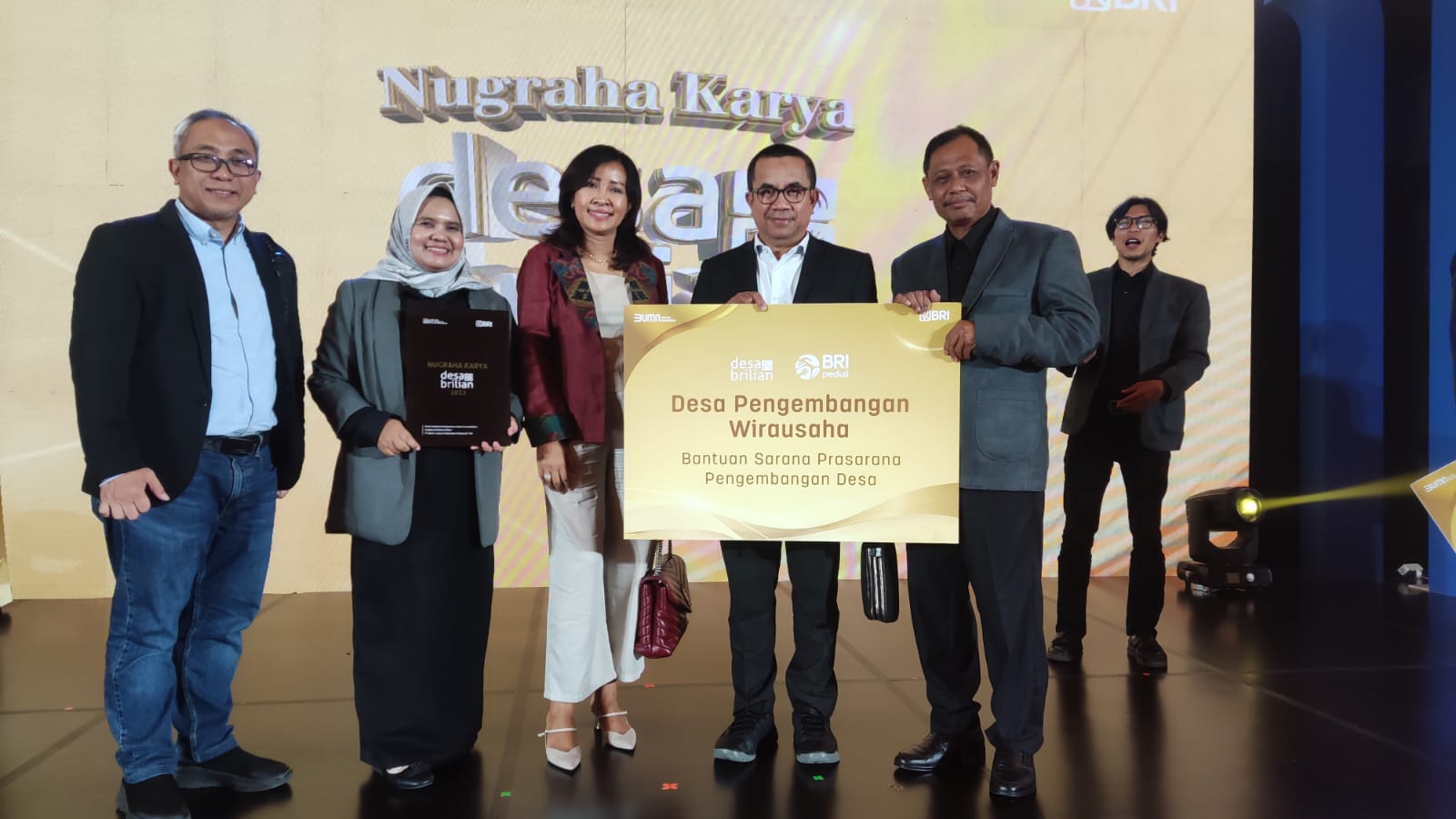 Membanggakan : Kepala Desa Sukomulyo Kecamatan Manyar, Subiyanto (kanan) menerima penghargaan dari Direksi Bank BRI dan para dewan juri kompetisi Nugraha Karya Desa BRILian 2023.