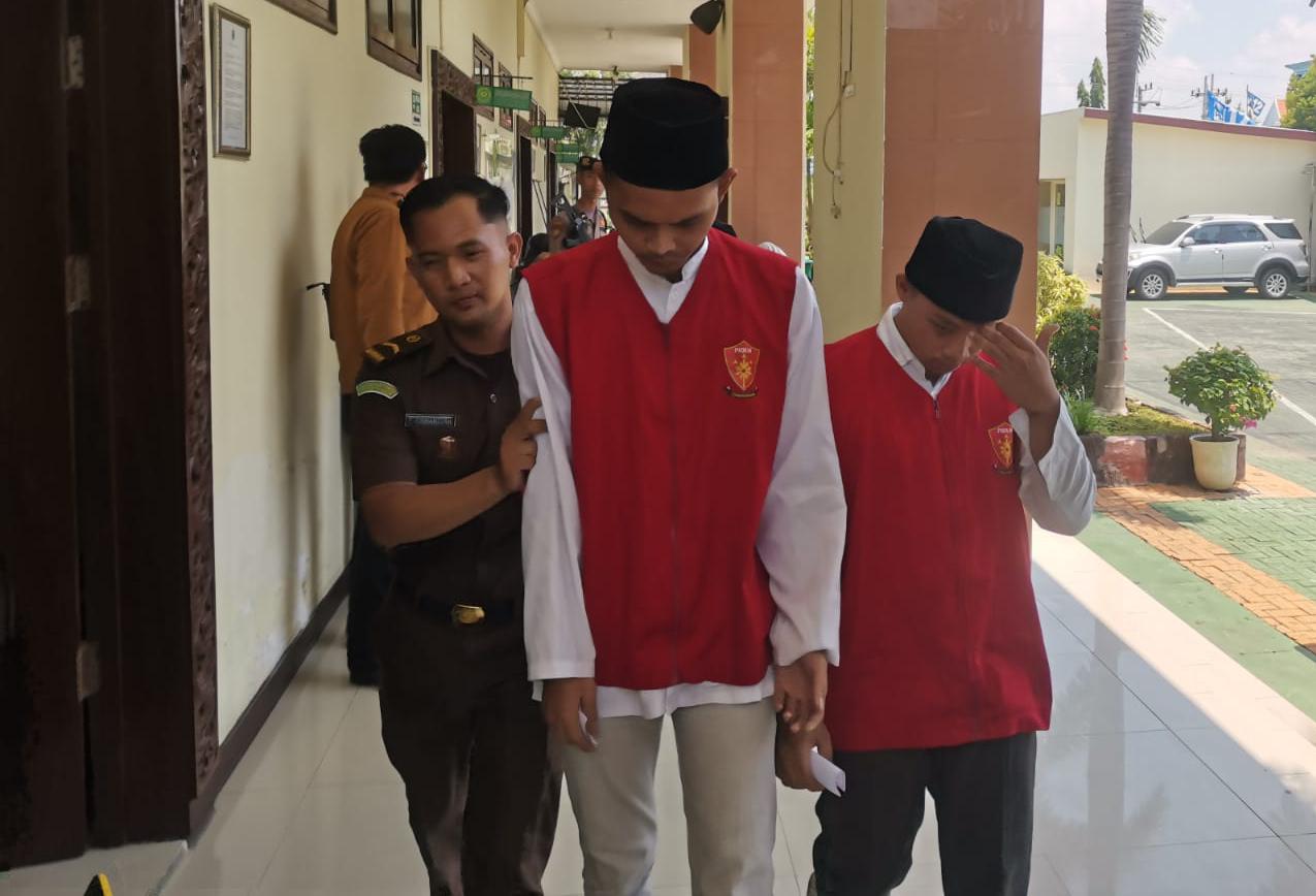 TERTUNDUK: Tersangka Hengky Pratama Susanto dan Irfan Suryadi usai menjalanj sidang di PN Gresik.