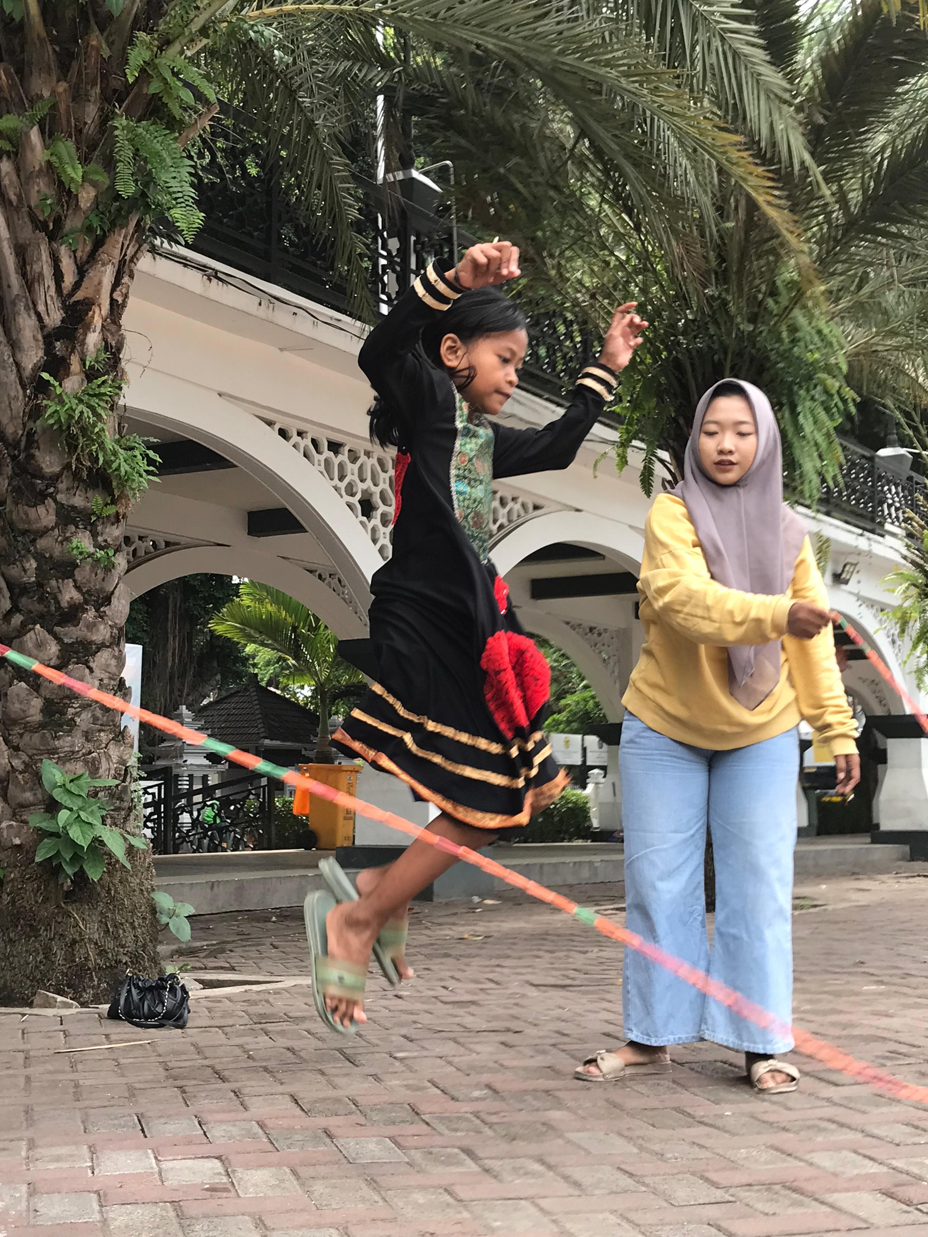 LOMPAT KARET: Dua anak-anak mempraktikkan permainan lompat tali atau karet yang trending saat tahun 1970-an