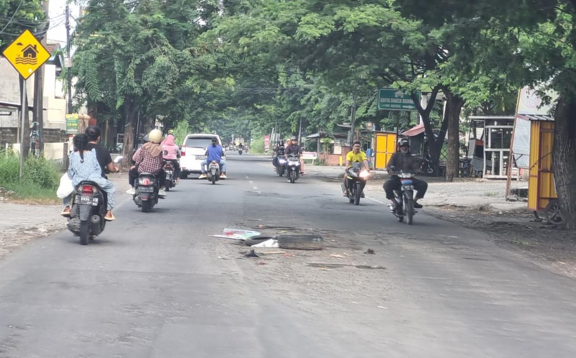 BERLUBANG: Usai banjir surut di Jalan Raya Morowudi, Kecamatan Cerme terlihat berlubang rusak parah.