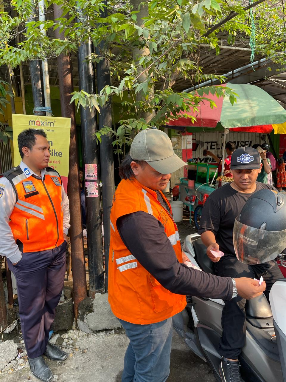 PELAYANAN: Jukir saat melayani pengendara yang parkir di salah satu ruas jalan.