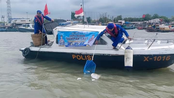 BERSIHKAN SAMPAH LAUT: Anggota Satpolairud  Polres Gresik menggunakan Kapal Polisi X-1016 untuk membersihkan sampah di laut Perairan Gresik.