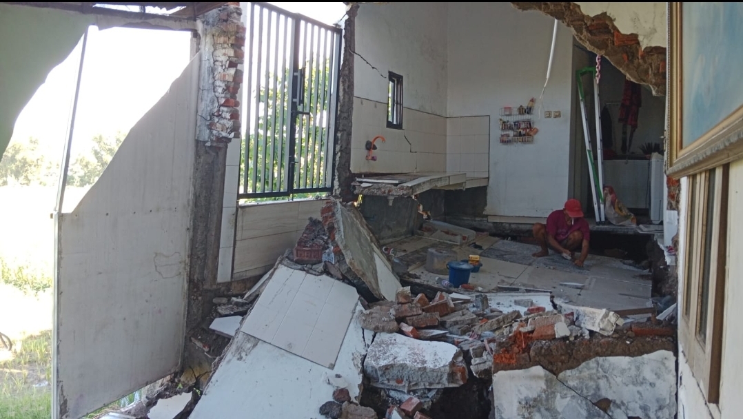 AMBLES: Kondisi rumah di Perumahan Graha Mutiara Indah Driyorejo yang rusak parah setelah tanah di sekitarnya ambles kemarin.
