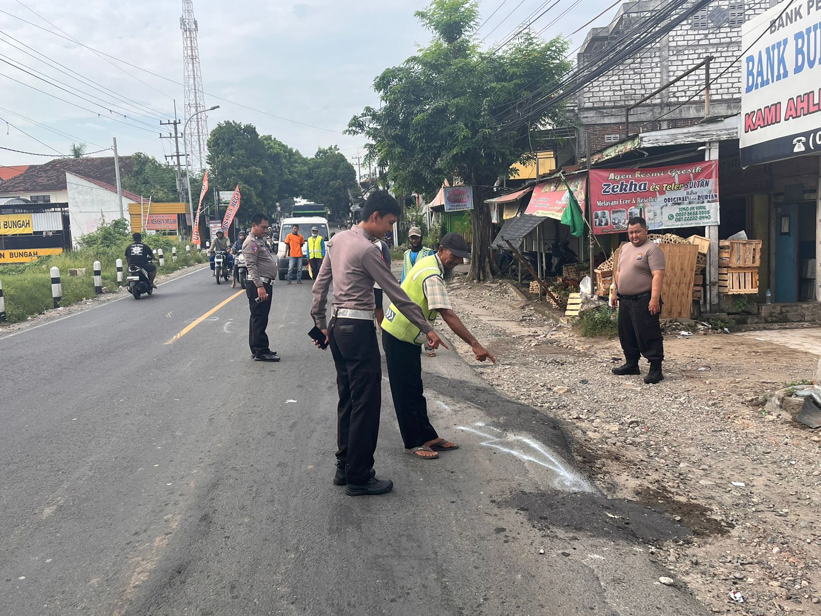 OLAH TKP: Anggota Unit Laka Satlantas Polres Gresik melakukan olah TKP kecelakaan di pertigaan pasar Bungah Jalan Raya Desa Bungah, Kecamatan Bungah.
