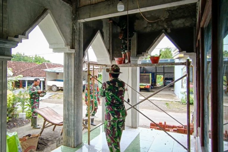 GOTONG ROYONG : Anggota Satgas TMMD bersama warga bergotong royong melajukan pembangunan dan perehaban tempat ibadah di Desa Sembung, Kecamatan Wringinanom.