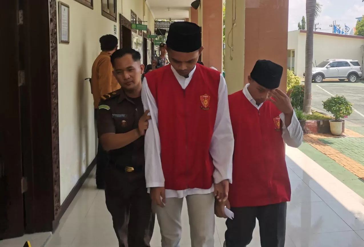 TERTUNDUK: Tersangka Hengky Pratama Susanto dan Irfan Suryadi usai menjalanj sidang di PN Gresik.