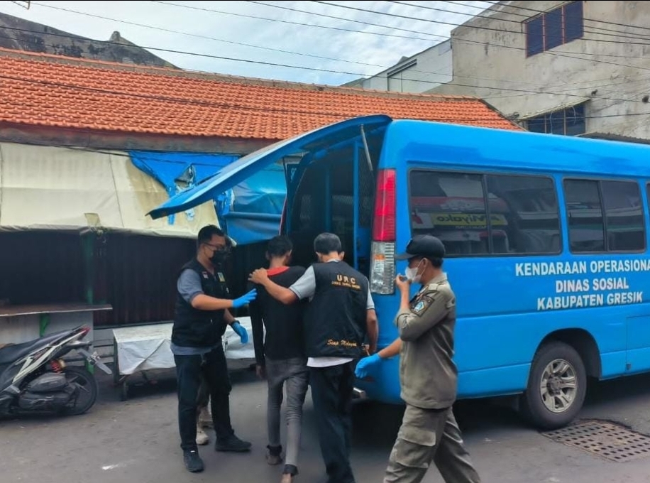 DIAMANKAN: URC Dinsos bersama Satpol PP dan petugas kesehatan saat mengamankan ODGJ Pasar Gresik yang telah memukul warga hingga berdarah.