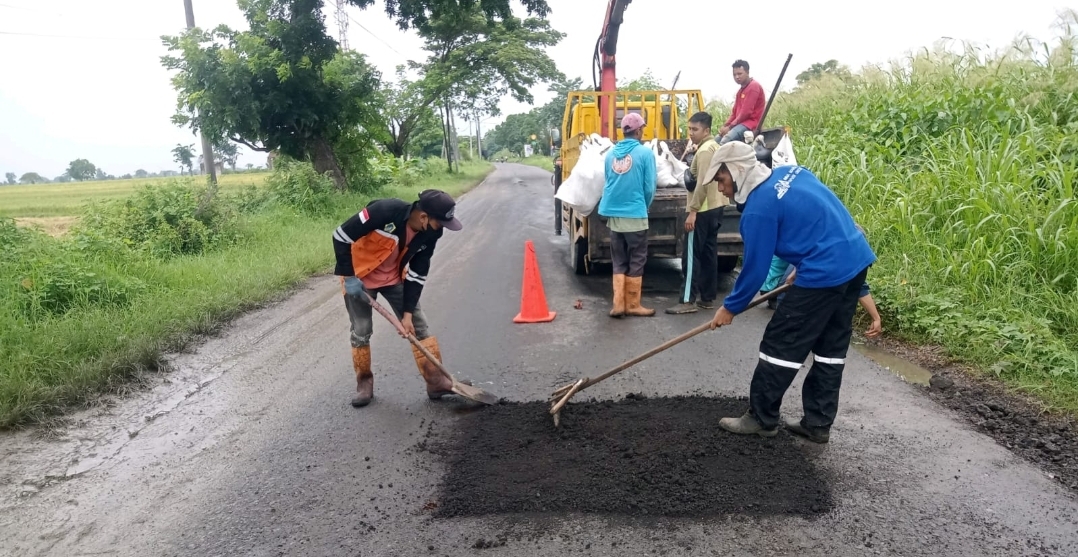 TAMBAL SULAM: URC Dinas PU Gresik berjibaku melakukan perbaikan jalan rusak yang banyak terjadi.