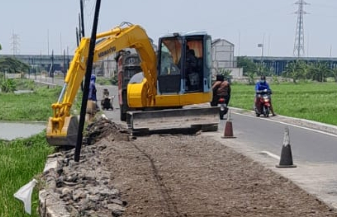 MULAI DIPERBAIKI: Alat berat terlihat meratakan tanah di lokasi ambrolnya Jalan Banjarsari - Kedanyang.