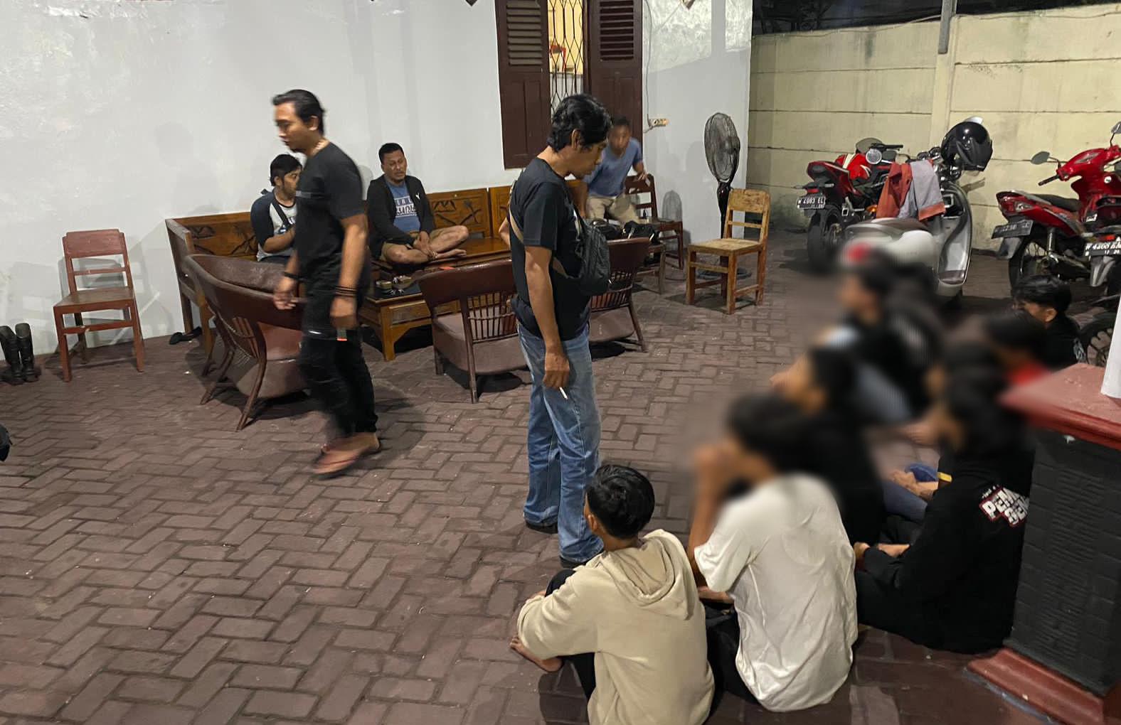 BENTROK : Anggota Resmob Satreskrim Polres Gresik saat mengamankan para oknum perguruan silat yang bentrok dengan anggota perguruan lain saat bagi takjil, Desa Dungus, Kecamatan Cerme.