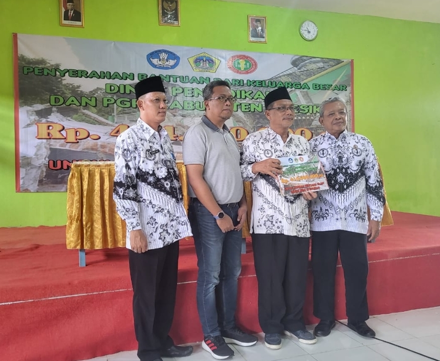 BERI BANTUAN: Sekretaris Dispendik Gresik Herawan Eka Kusuma (dua dari kiri) didampingi Sekretaris PGRI Gresik Sutrisno menyerahkan bantuan kepada PGRI Bawean.