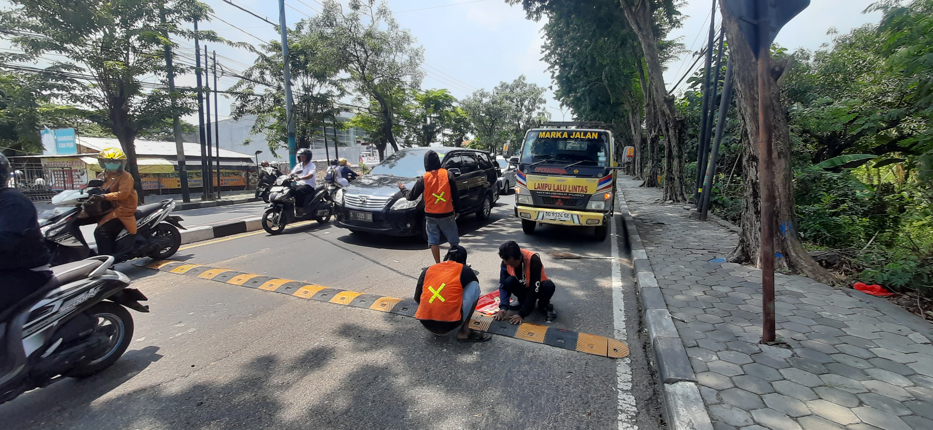 TETAP DIPASANG: Petugas Dishub Gresik menambahkan stiker pantul di speed bump depan Mapolres.