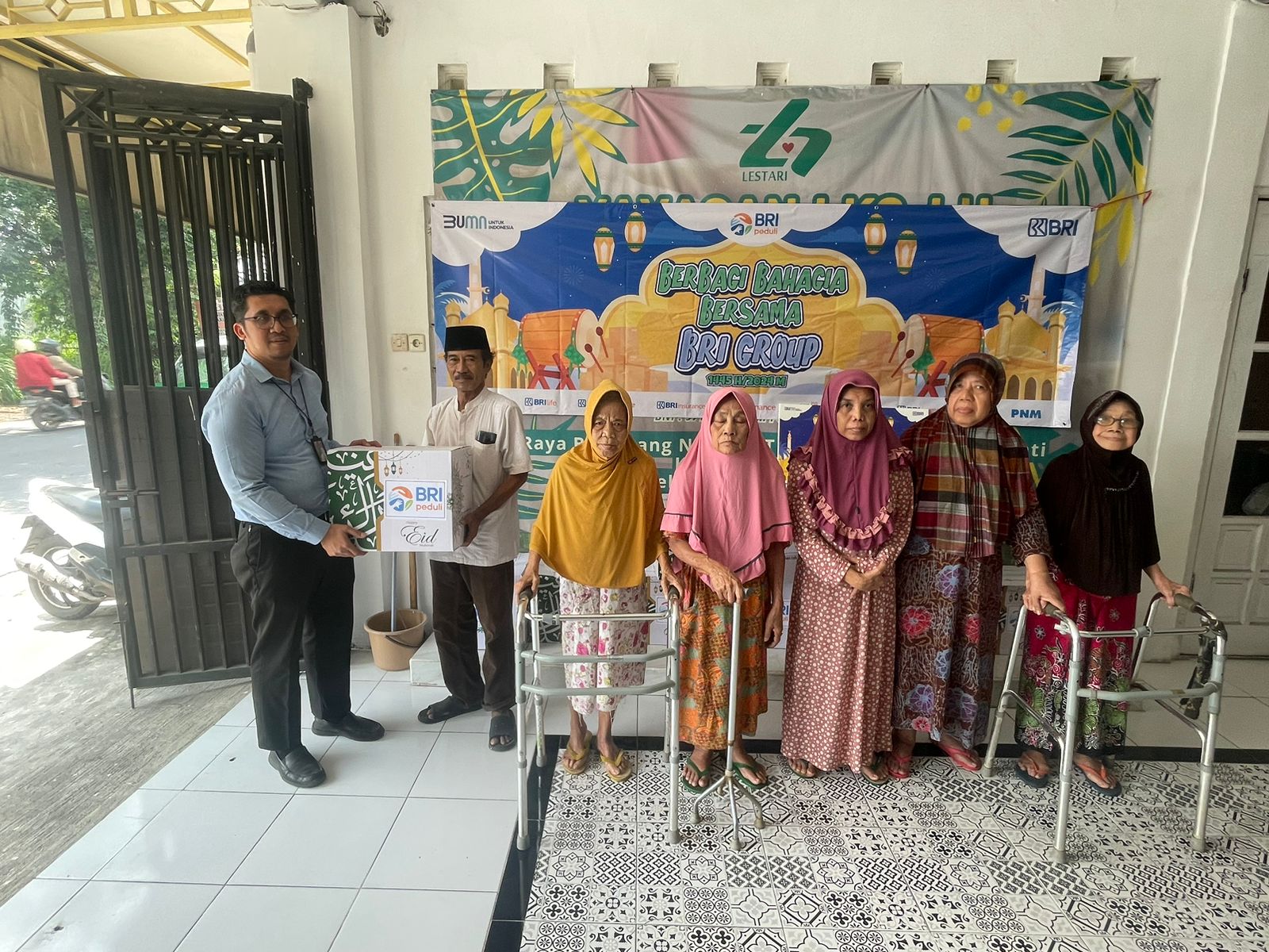 Berbagi : Supervisor BRI BO Gresik, Adji W menyerahkan secara simbolis paket bingkisan lebaran kepada Kepala Panti Werdha Lestari Menganti, Hariyanto.