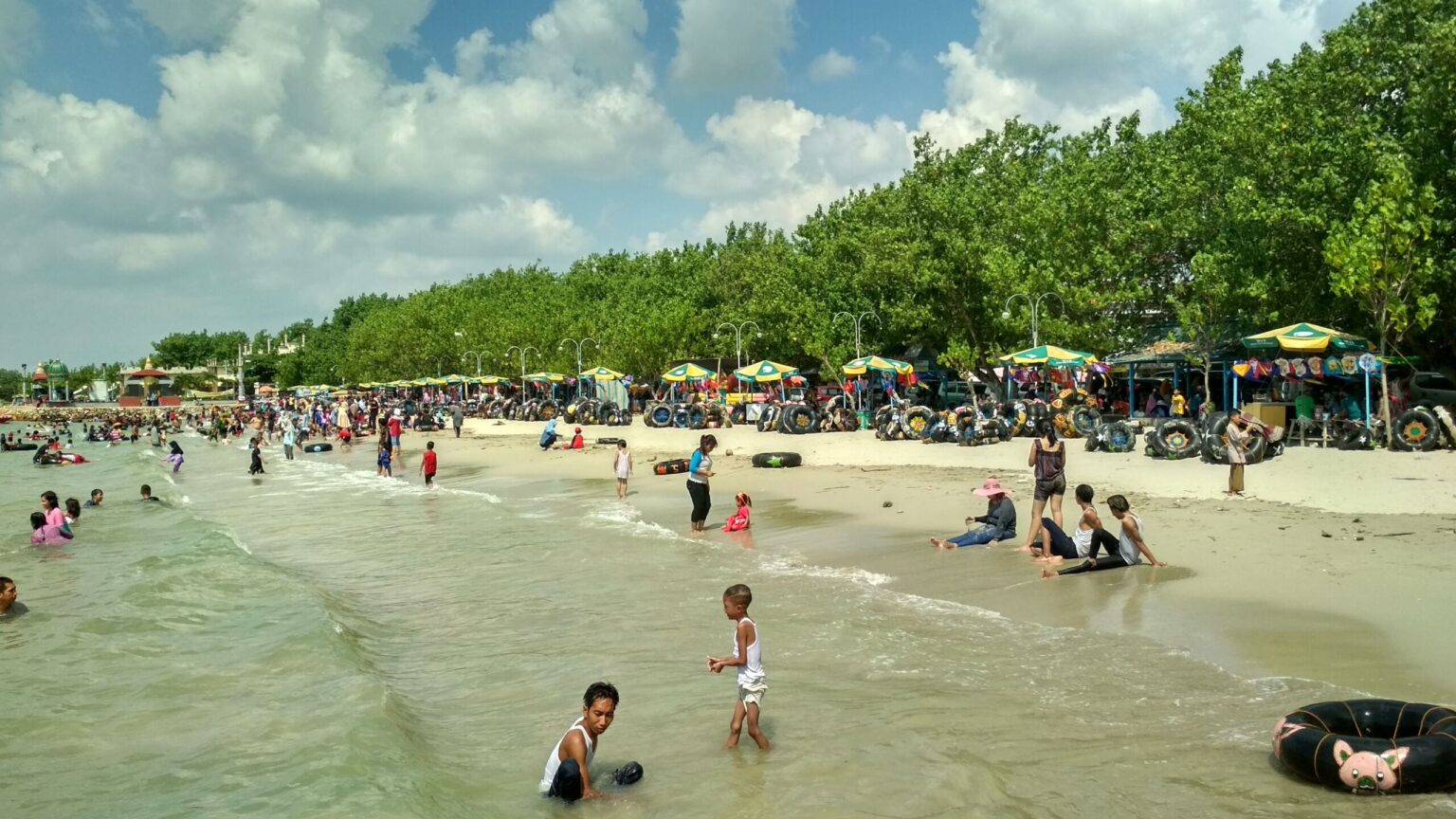 RAMAI: Para pengunjung sedang menikmati keindahan pasir putih di pantai Dalegan Gresik.