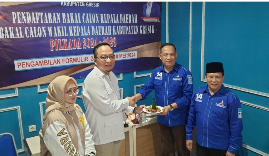 Ketua DPC Partai Demokrat Gresik Supriyanto menyerahkan tumpeng kepada Ketua DPC Gerindra Gresik dr Asluchul Alif usai mendaftar penjaringan calon kepada daerah.