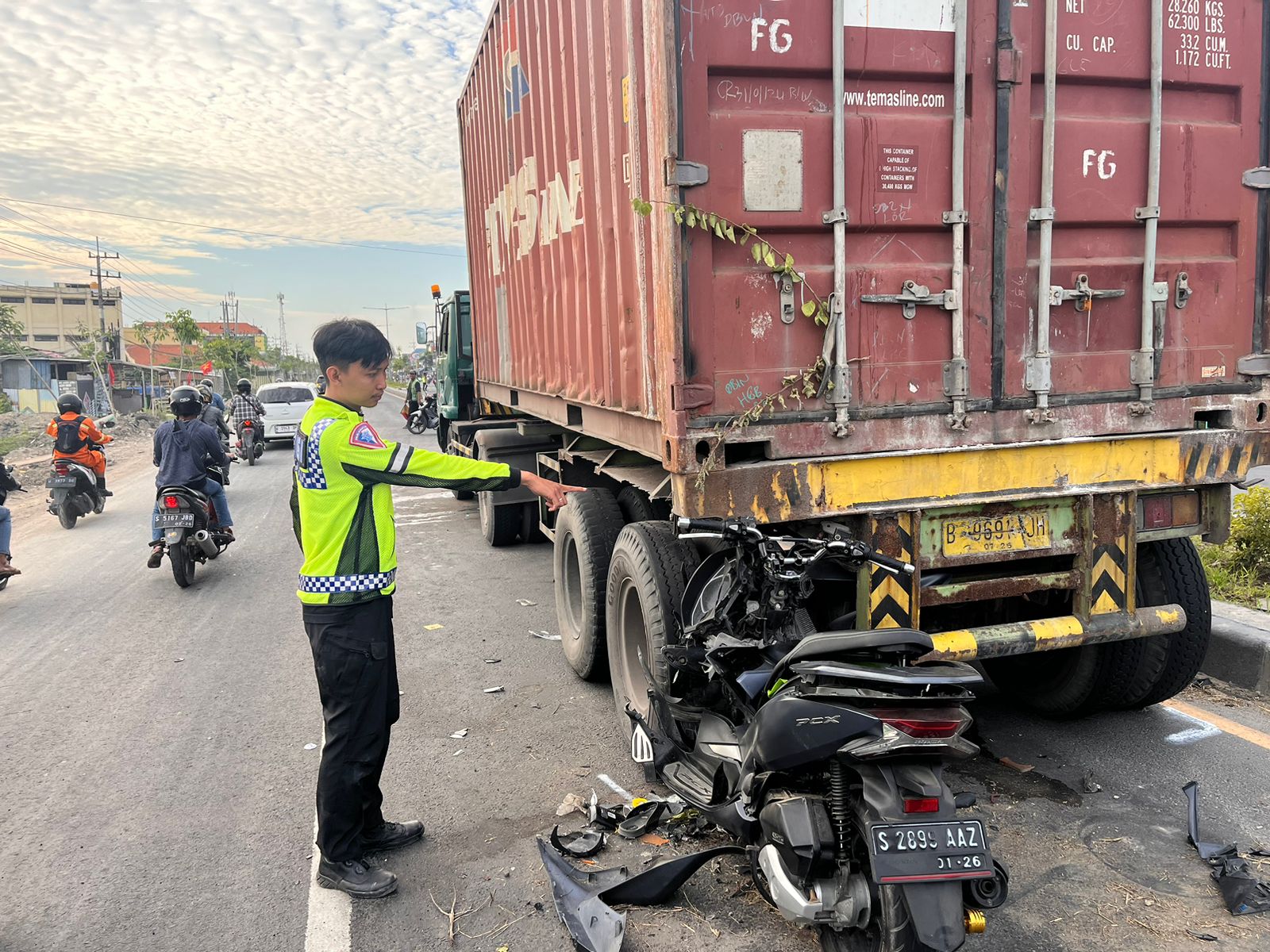 BAHAYA: Pengendara motor menabrak trailer yang sedang parkir di pinggir jalan raya.