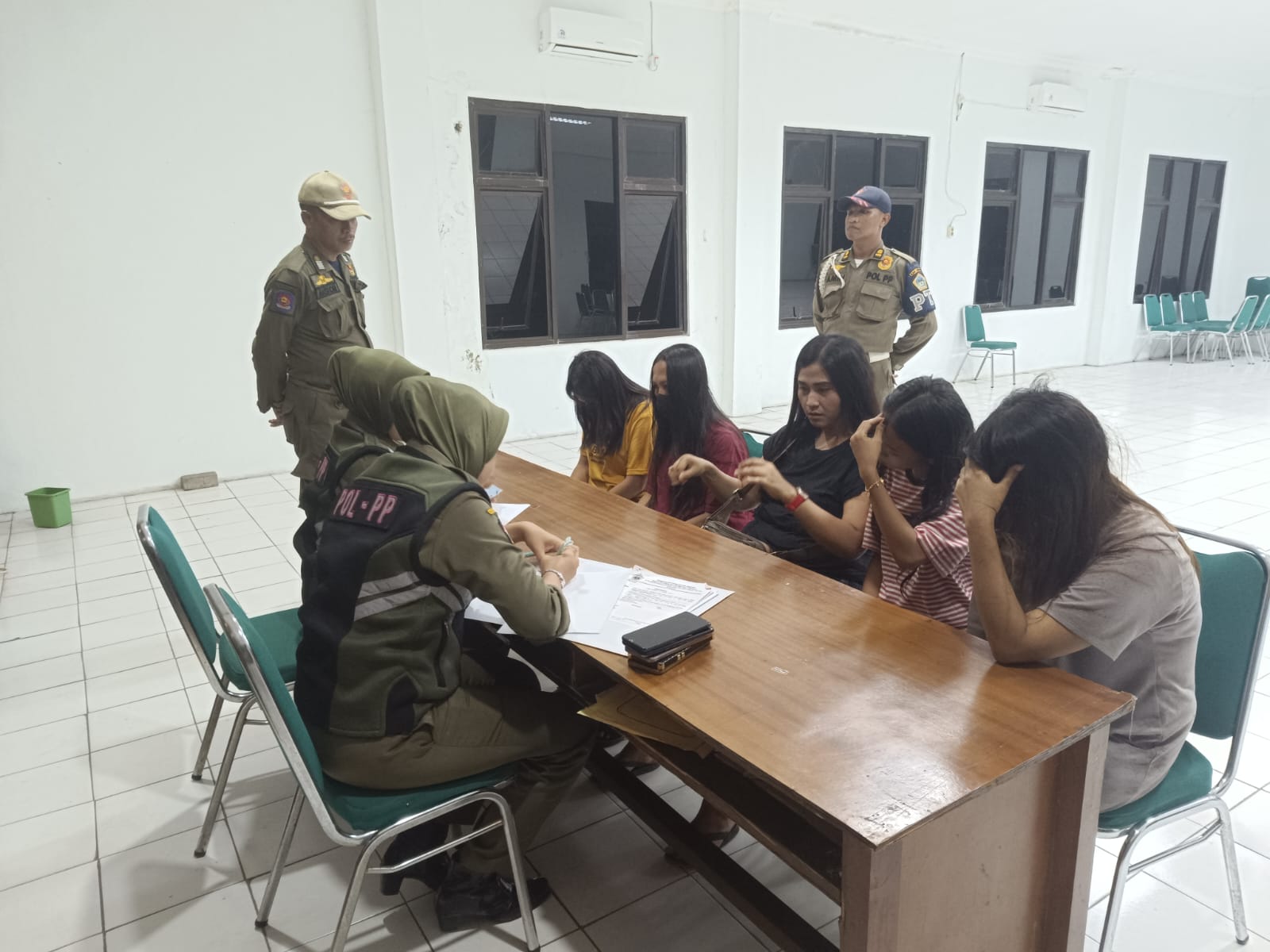 DIAMANKAN: Anggota satpol PP mengamankan pramusaji warung remang - remang di Desa Banjarsari, Kecamatan Cerme, Kabupaten Gresik.