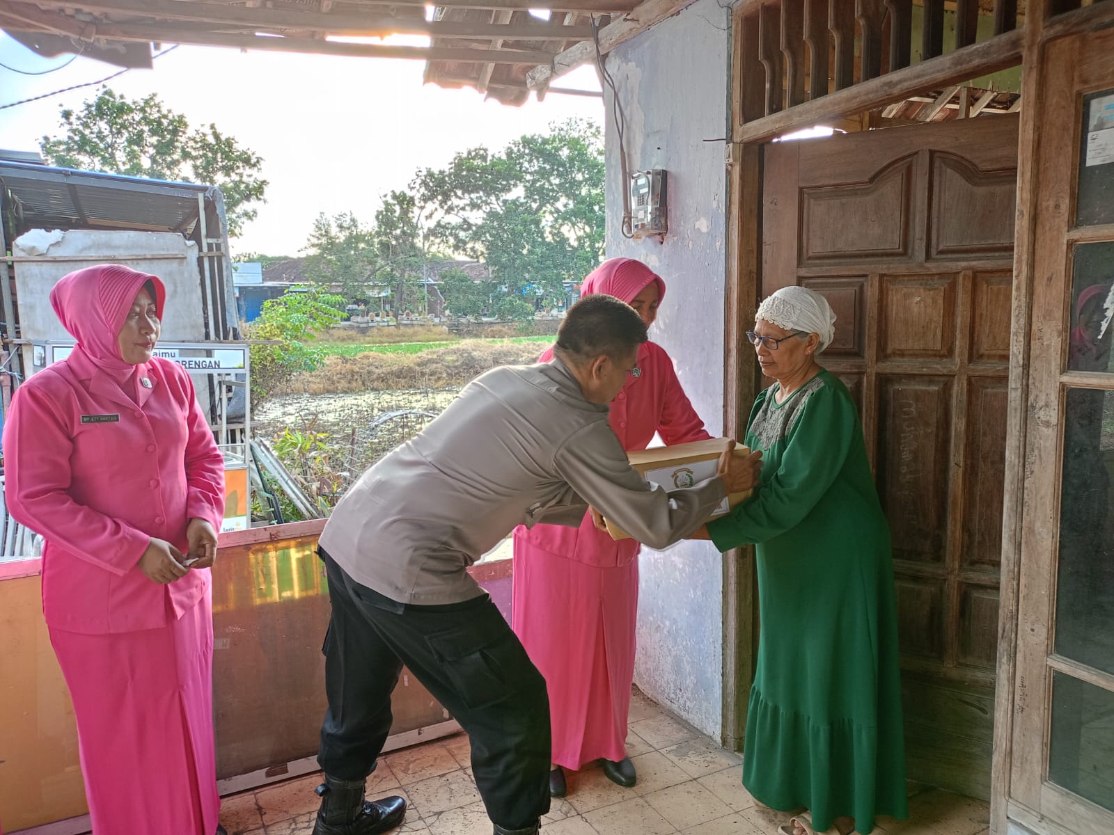 BAGIKAN SEMBAKO: Bhayangkari Polsek Benjeng membagi sembako kepada Janda dan warga kurang mampu di Dusun Medangan, Desa Metatu.