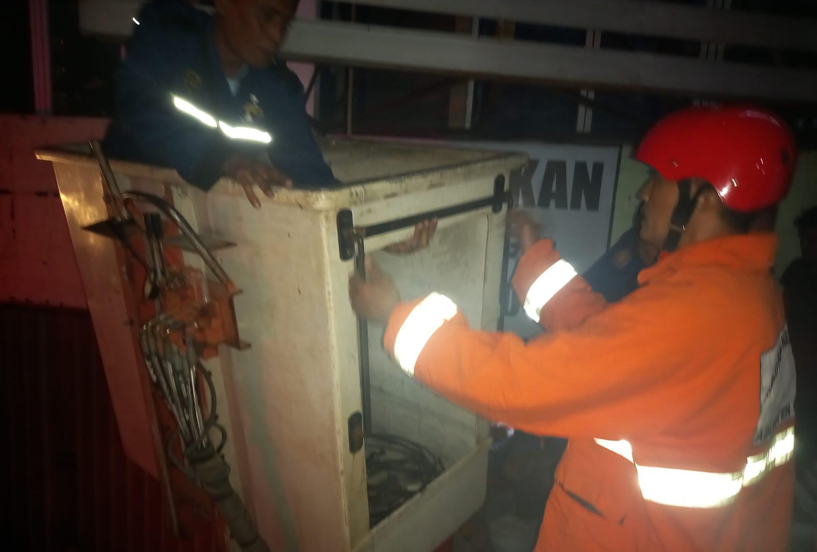 DITOLONG: Petugas Damkarla Kabupaten Gresik memberikan pertolongan kepada seorang pekerja partisi reklame yang pingsan di atas papan reklame Jalan Wahidin Sudirohusodo.