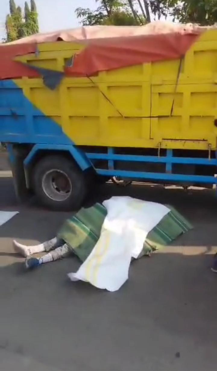 KECELAKAAN: Korban pengendara motor tergelatak usai terlibat kecelakaan dengan dump truk Mitsubishi Fuso di Jalan Raya Desa Wringinanom.