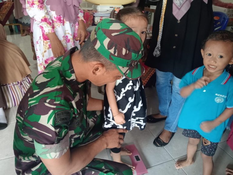 CEGAH STUNTING: Babinsa Serda Eko Dian Santoso saat membantu pendampingan pelayanan kesehatan masyarakat sehingga pelaksanaan berjalan dengan lancar.