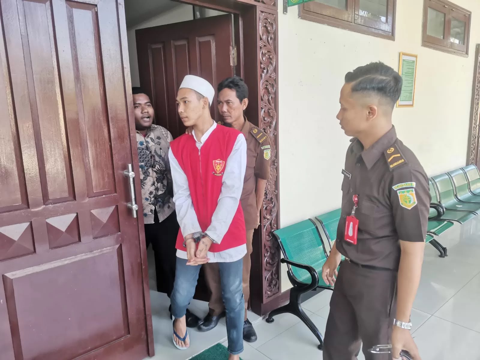 MENUNDUK: Terdakwa Abdullah Ibnu Khoir digelandang petugas menuju sel tahanan usai menjalani sidang di PN Gresik.