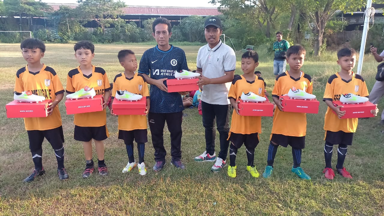 Pengurus dan Pemain SSB Peganden dari Kecematan Manyar berfoto bersama perwakilan PSSI melalui Asoisasi Kabupaten PSSI Gresik saat menerima sepatu dari PT Freeport Indonesia.