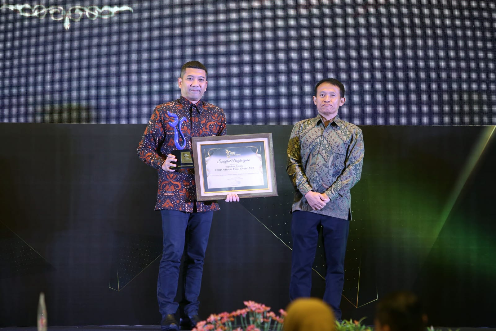 ANDY SATRIA/RADAR SURABAYA PENGHARGAAN :  Wakapolres Polres Gresik Kompol Danu mewakili Kapolres Gresik AKBP Aditya Panji Anom saat menerima Radar Surabaya Awards dari Komisaris Radar Suraya