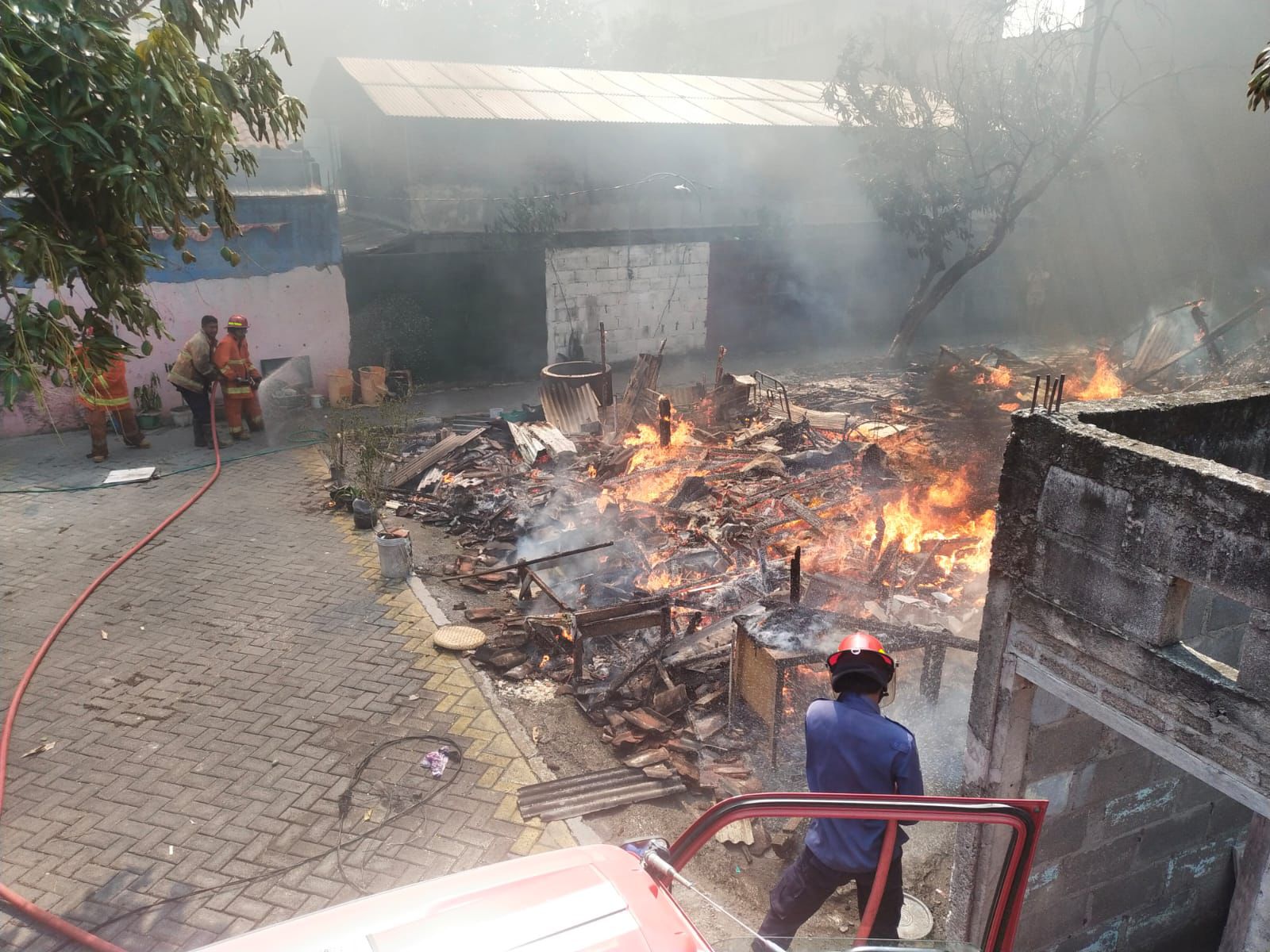 PEMADAMAN: Petugas Damkarla Kabupaten Gresik saat memadamkan rumah kos yang terbakar di Jalan Dr. Soetomo Gg 2D No. 18, Kelurahan Ngipik, Kecamatan Gresik