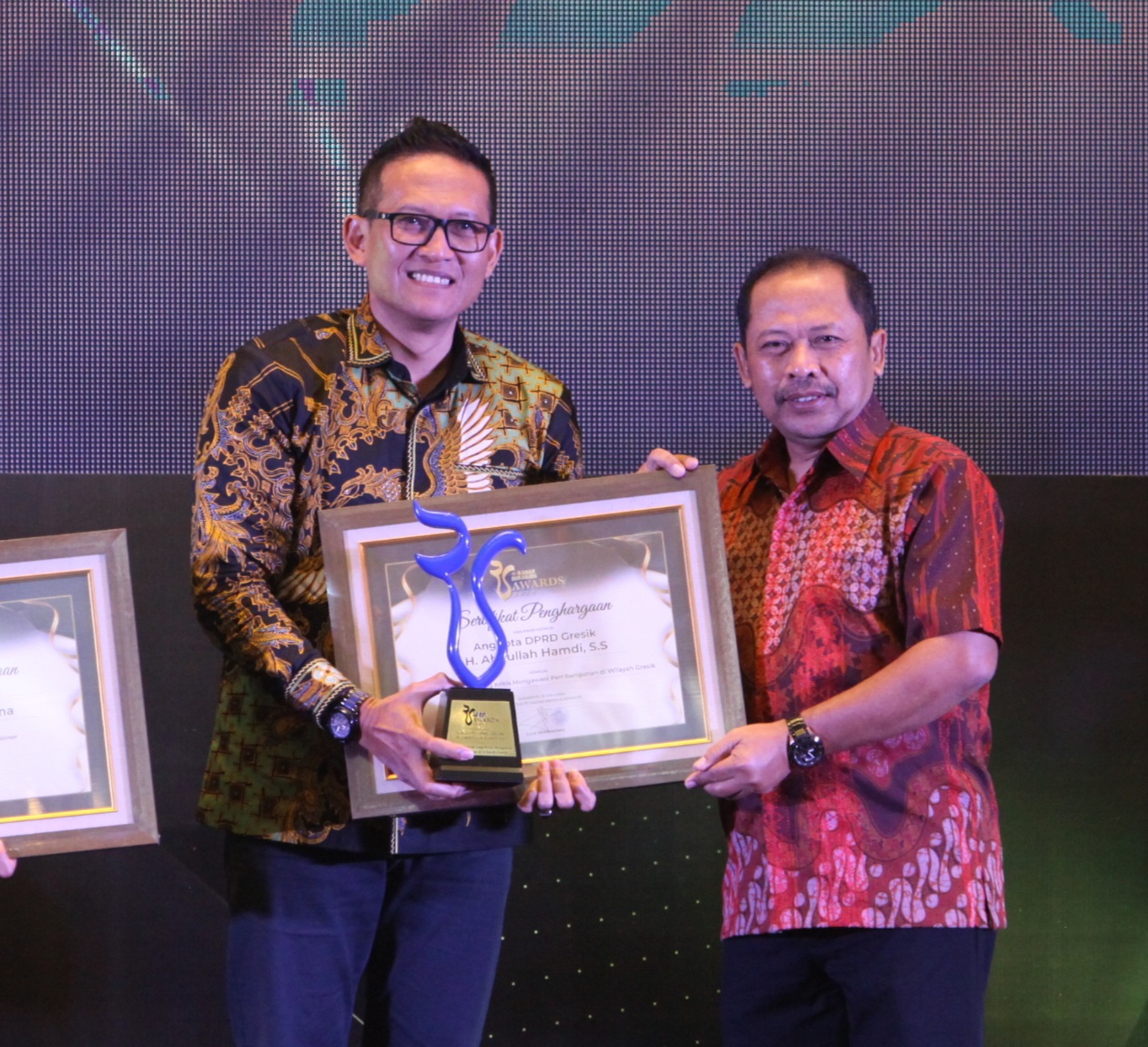 H. Abdullah Hamdi, S.S. saat menerima penghargaan Radar Surabaya Awards Kategori Tokoh Inspiratif dari Direktur PT Radar Media Surabaya Lilik Widyantoro.