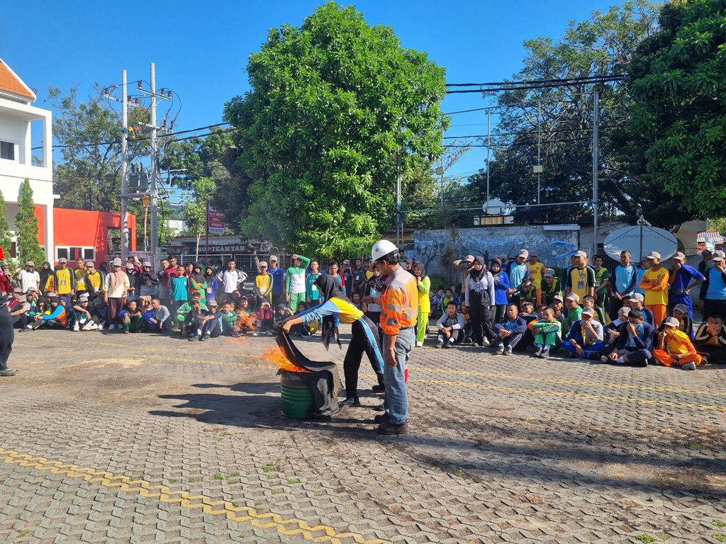 PENUTUPAN: Salah satu siswa baru SMK Semen Gresik praktik langsung memadamkan api dengan karung goni.