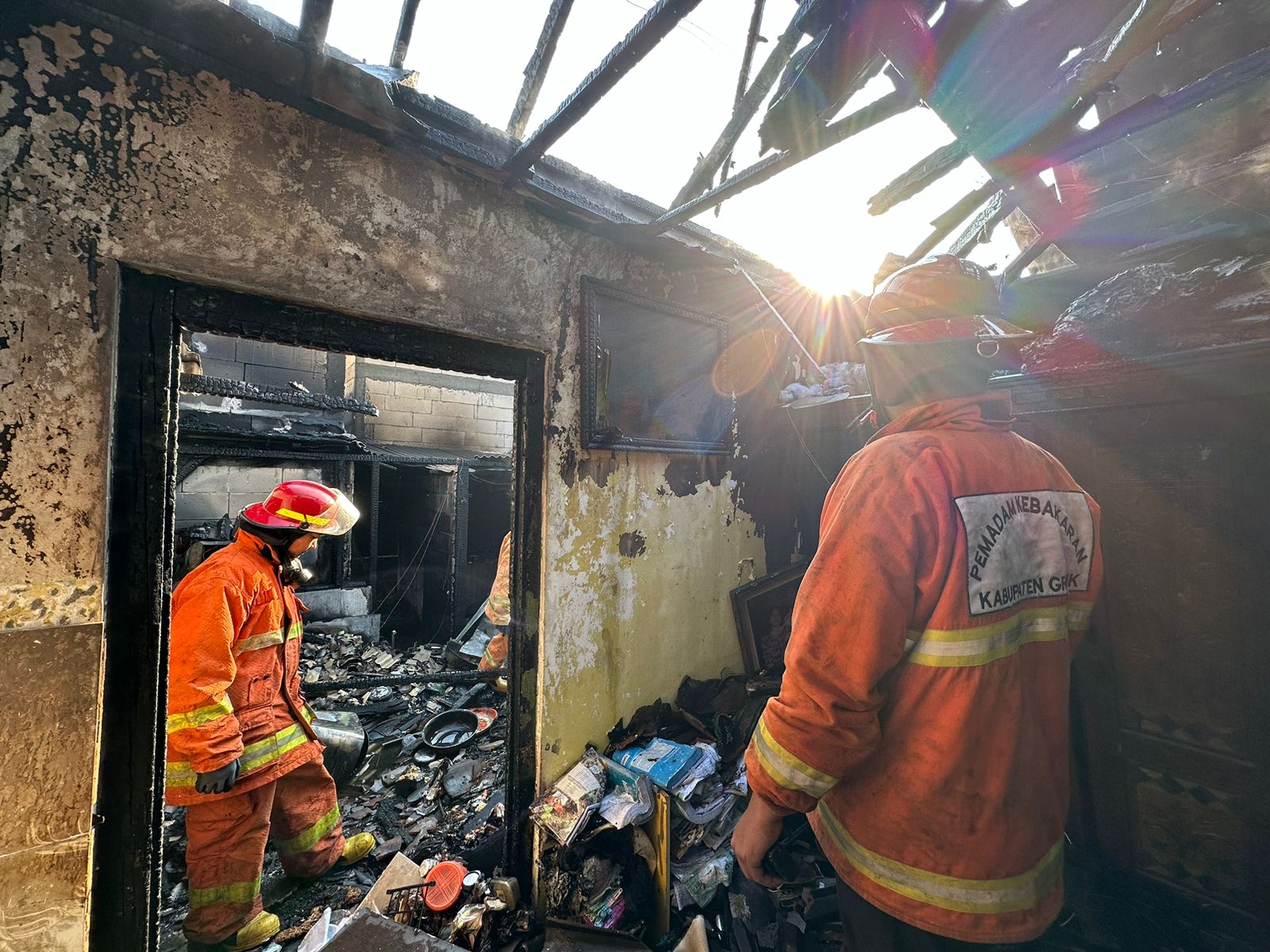 PEMADAMAN: Anggota Damkarla Gresik melakukan pemadaman kebakaran sebuah rumah di Jalan Kapten Darmo Sugondo Gg. X, RT 003 RW 002, Kelurahan Indro, Kecamatan Kebomas, Gresik, Jumat (16/8).