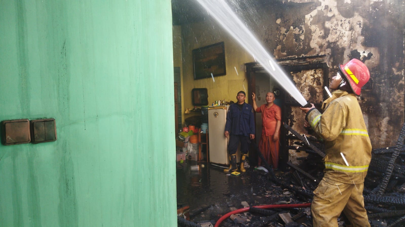 PEMADAMAN: Anggota Damkarla Gresik dan petugas PMK Petrokimia Gresik melakukan pemadaman kebakaran rumah dua lantai di Perum BP Randuagung Jalan Cimanuk, Randuagung, Kecamatan Kebomas, Gresik