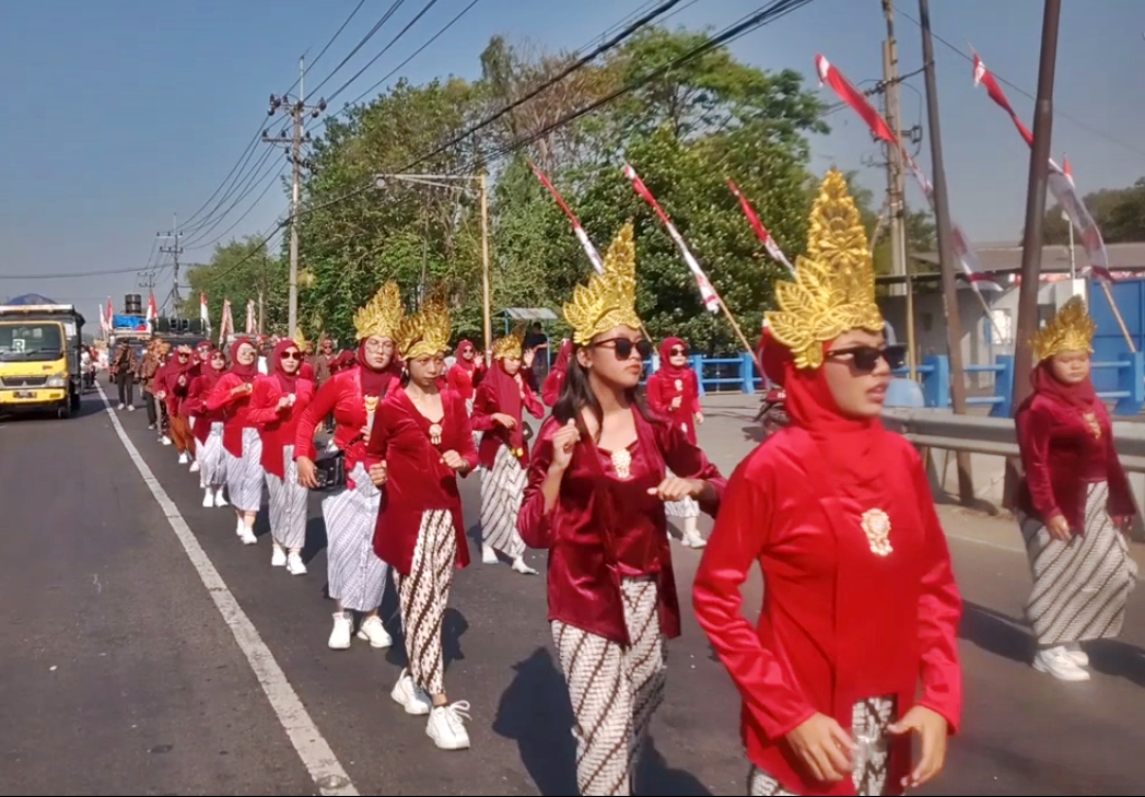 SEMARAK: Para peserta karnaval di Desa Krikilan, Kecamatan Driyorejo menampilkan pakaian adat dan tarian tradisional saat melintasi Jalan Raya Legundi sampai Balai Desa Krikilan, Kecamatan Driyorejo.