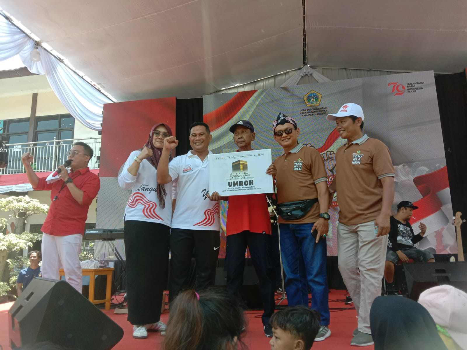 PEMENANG UMRAH : Kades Yosowilangun Gresik, Abdur Rosyid memberikan hadiah kepada pemenang jalan sehat yang berhadiah umrah kepada Yusuf Kusnan.