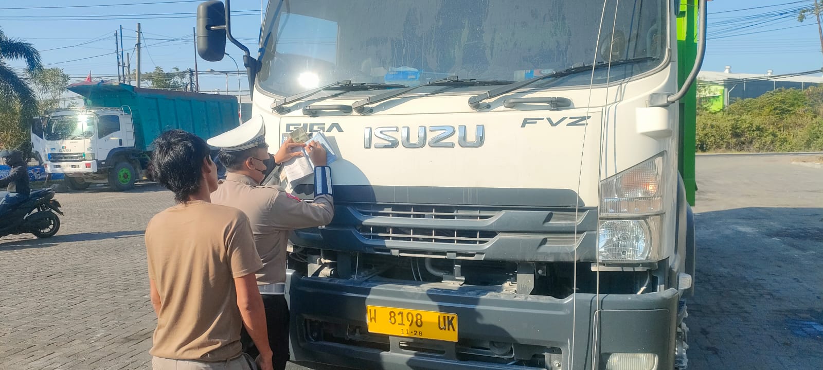 DITILANG: Anggota Satlantas Polres Gresik  menilang truk yang melanggar saat berada di Jalan Raya Manyar.