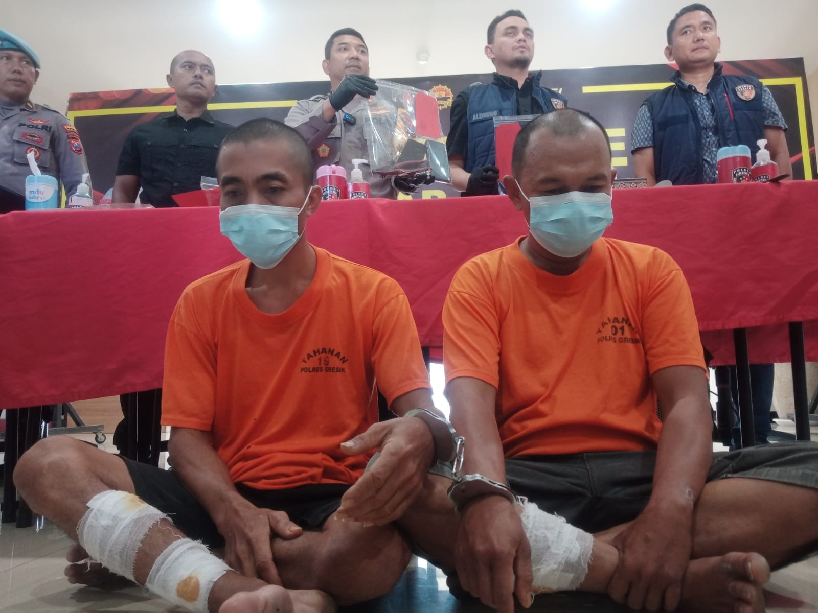 DITEMBAK : Kedua tersangka Jupri dan Asmad hanya bisa menunduk di Mapolres Gresik dengan kedua kakinya di perban usai di tembak petugas karena berusaha kabur dan melawan saat diamankan.