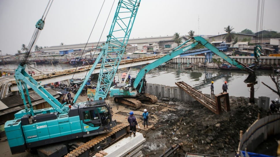 Sejumlah pekerja menggunakan eskavator dan crane menyelesaikan pembangunan tanggul pantai.