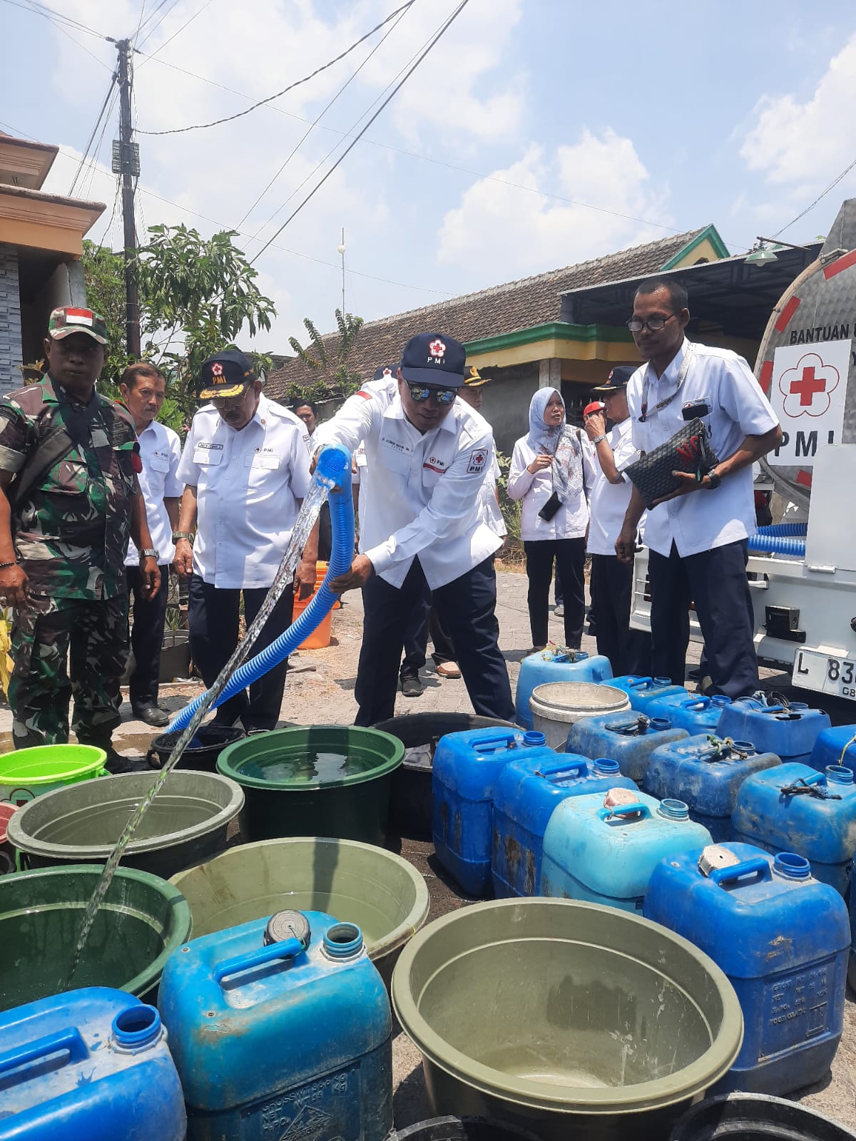 Ketua PMI Gresik Achmad Nadlir saat membagikan air bersih kepada warga Desa Dampaan