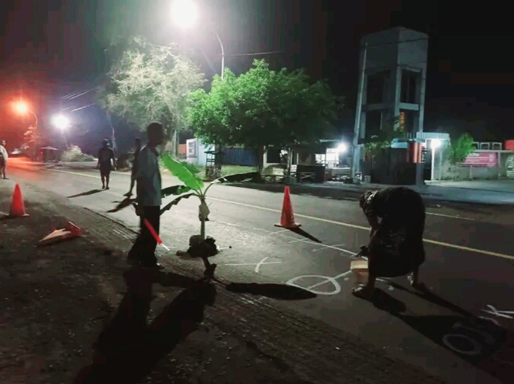 Warga Sidayu, Gresik saat melakukan aksi corat-coret dan penanaman pohon pisang di lokasi jalan berlubang.