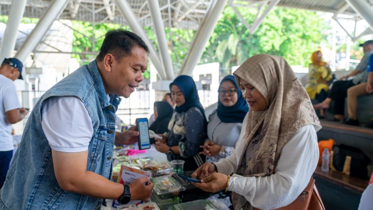 SERBA DIGITAL: Regional Mikro Banking Head (RMBH) Rahadi Kristiyono membayar pembelian produk UMKM melalui Qris.